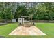 Landscaped backyard featuring a fire pit, shed, swing, and lush greenery at 341 Jodeco Station E Cir, Stockbridge, GA 30281