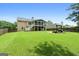 Spacious backyard with lush green grass, a fire pit, and a screened-in porch for outdoor entertaining at 341 Jodeco Station E Cir, Stockbridge, GA 30281