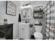 Stylish half bath featuring white vanity, a decorative mirror, and shelving at 341 Jodeco Station E Cir, Stockbridge, GA 30281