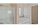 Bathroom featuring a glass enclosed shower, large tub, and natural light at 697 Emporia Loop, Mcdonough, GA 30253