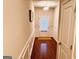 Welcoming hallway with hardwood floors, paneled walls and a view of the back door at 697 Emporia Loop, Mcdonough, GA 30253