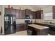 Well-equipped kitchen with dark cabinets, granite countertops, and stainless steel appliances at 697 Emporia Loop, Mcdonough, GA 30253