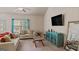 Cozy living room with vaulted ceiling, neutral furniture and large windows with blue curtains at 697 Emporia Loop, Mcdonough, GA 30253