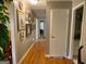 Hallway with hardwood floors and walls adorned with pictures, leading to other parts of the home at 7111 Indian Creek Sw Cir, Covington, GA 30014