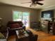 Cozy living room featuring wood flooring, a ceiling fan, a sliding glass door, and a fireplace with a TV above at 7111 Indian Creek Sw Cir, Covington, GA 30014