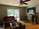 Cozy living room featuring wood flooring, a ceiling fan, a sliding glass door, and a fireplace with a TV above at 7111 Indian Creek Sw Cir, Covington, GA 30014