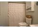 Cozy bathroom with a decorative shower curtain, a toilet, and a cabinet for storage at 160 Laurel Ln, Social Circle, GA 30025