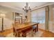Dining room featuring a wooden table, bench seating, hardwood floors, and a decorative chandelier at 160 Laurel Ln, Social Circle, GA 30025