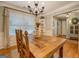 Dining room showcases a large wooden table, hardwood floors, natural light, and a chandelier at 160 Laurel Ln, Social Circle, GA 30025