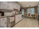 Kitchen featuring white cabinets, stainless steel appliances, and a view into an adjacent dining area at 160 Laurel Ln, Social Circle, GA 30025