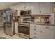 Kitchen boasting stainless steel appliances, white cabinets, and granite countertops at 160 Laurel Ln, Social Circle, GA 30025