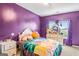 Vibrant bedroom with purple walls, plush bedding, and natural light from the window, creating a cozy retreat at 412 Culloden Moor, Mcdongough, GA 30253
