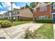 View of the townhouse with a private driveway surrounded by green lawn and mature landscaping at 4862 Park Cir, Atlanta, GA 30349