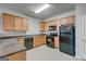 Well-lit kitchen boasting wooden cabinets, black appliances, and durable countertops at 4862 Park Cir, Atlanta, GA 30349