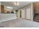 Carpeted living room with stairs and view into kitchen with natural wood cabinets at 4862 Park Cir, Atlanta, GA 30349