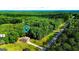 Expansive aerial view of a brick home nestled on a wooded lot with a long driveway and street access at 6830 Peeksville Rd, Mcdonough, GA 30252