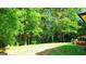 Spacious backyard features mature trees, grassy areas, and a partial view of the home's deck at 6830 Peeksville Rd, Mcdonough, GA 30252