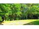 Large backyard with a lush green lawn and surrounded by dense trees, offering privacy and space at 6830 Peeksville Rd, Mcdonough, GA 30252