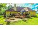 Home's backyard features a wooden deck, stone fire pit, and beautifully landscaped lawn at 6830 Peeksville Rd, Mcdonough, GA 30252