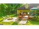 Backyard area showcases a deck, patio furniture, a stone fire pit, and lush landscaping at 6830 Peeksville Rd, Mcdonough, GA 30252