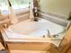 Bright bathroom features a relaxing soaking tub with tile surround and decorative accents at 6830 Peeksville Rd, Mcdonough, GA 30252