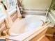 Bright bathroom features a relaxing soaking tub with tile surround and decorative accents at 6830 Peeksville Rd, Mcdonough, GA 30252