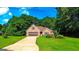Well-maintained brick house with a two-car garage and beautiful landscaping surrounded by mature trees at 6830 Peeksville Rd, Mcdonough, GA 30252