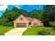 Charming brick home featuring an attached garage, manicured lawn, and mature trees in a desirable neighborhood at 6830 Peeksville Rd, Mcdonough, GA 30252