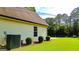 Close up side view of tan home with manicured lawn, shrubbery and an AC unit at 6830 Peeksville Rd, Mcdonough, GA 30252