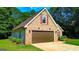 Spacious attached two-car garage offering convenient access and additional storage, surrounded by lush landscaping at 6830 Peeksville Rd, Mcdonough, GA 30252