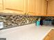 The kitchen boasts stylish countertops and a multicolored backsplash, complemented by light wood cabinets at 6830 Peeksville Rd, Mcdonough, GA 30252