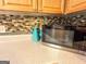 Kitchen countertop featuring modern microwave, decorative backsplash and warm, wood cabinetry at 6830 Peeksville Rd, Mcdonough, GA 30252