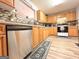 Well-lit kitchen featuring modern stainless steel appliances, wooden cabinets, and mosaic tile backsplash at 6830 Peeksville Rd, Mcdonough, GA 30252