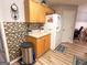 Well-lit kitchen with wood cabinets, white refrigerator, and decorative backsplash at 6830 Peeksville Rd, Mcdonough, GA 30252