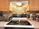 Kitchen electric range with wood cabinetry and backsplash, with countertop appliances in view at 6830 Peeksville Rd, Mcdonough, GA 30252