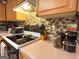 Kitchen range area with smooth cooktop, tiled backsplash, and adjacent storage of countertop appliances at 6830 Peeksville Rd, Mcdonough, GA 30252