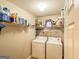 Functional laundry area with white washer and dryer set, and ample shelving space for storage at 6830 Peeksville Rd, Mcdonough, GA 30252