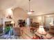 Bright living room with a stone fireplace, ceiling fan, and seamless flow to other areas, perfect for entertaining at 6830 Peeksville Rd, Mcdonough, GA 30252