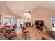 Open-concept living room featuring a stone fireplace, high ceilings, and a ceiling fan for comfortable living at 6830 Peeksville Rd, Mcdonough, GA 30252