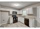 Efficient kitchen features black appliances, white cabinetry, and wood-style flooring at 1600 Coal Shovel Ne Trl, Conyers, GA 30013