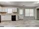Well-lit kitchen with modern black appliances, white cabinets, and wood-style flooring at 1600 Coal Shovel Ne Trl, Conyers, GA 30013