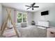 Bright bedroom featuring a tent bed, ceiling fan, and white dresser with flat screen tv at 345 Kerrith Dr, Stockbridge, GA 30281