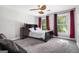 Carpeted bedroom with ceiling fan, large window, and black sleigh bed at 345 Kerrith Dr, Stockbridge, GA 30281