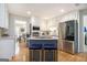 Bright kitchen with white cabinets, stainless appliances, granite counters and an island with bar stool seating at 345 Kerrith Dr, Stockbridge, GA 30281