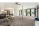 Spacious carpeted living room featuring a ceiling fan, many windows, and neutral colors at 345 Kerrith Dr, Stockbridge, GA 30281