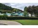 Community pool area featuring a zero-entry pool, water slide, splash pad, and plenty of seating under umbrellas at 345 Kerrith Drive Dr, Stockbridge, GA 30281