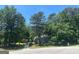 A stately two-story home nestled among mature trees, with a long driveway leading to the property at 345 Kerrith Drive Dr, Stockbridge, GA 30281