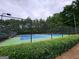 Community tennis courts featuring blue and green surfaces, surrounded by a black fence and green trees at 345 Kerrith Drive Dr, Stockbridge, GA 30281