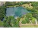 Scenic aerial view of a large lake surrounded by trees and a property with a dock and a pool at 3612 Bill Gardner Pkwy, Locust Grove, GA 30248