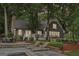 Secluded backyard features a stone patio with lounge chairs, lush landscaping and mature trees at 3612 Bill Gardner Pkwy, Locust Grove, GA 30248